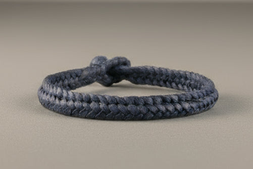 Navy blue braided bracelet on a gray background