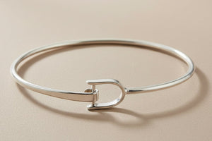 Silver bangle on a gray background