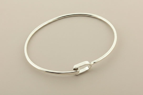 Silver bangle on a gray background