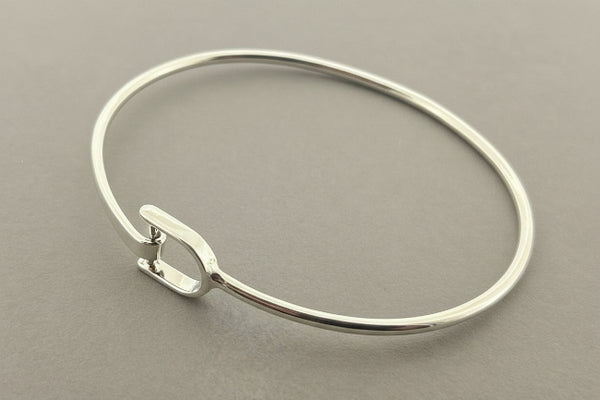 Silver bangle on a gray background