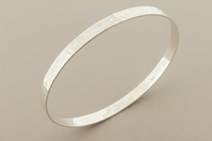 Silver bracelet on a gray background