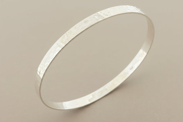 Silver bracelet on a gray background