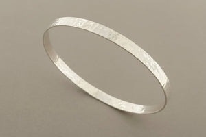 Silver bangle on a gray background