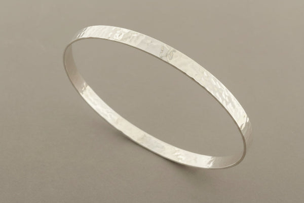 Silver bangle on a gray background