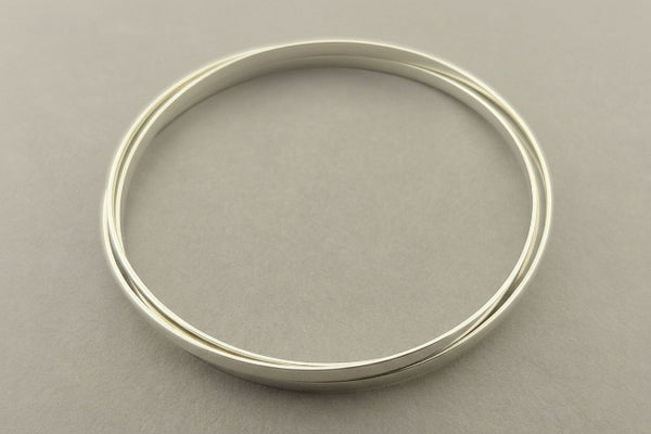 Silver bangle on a gray background