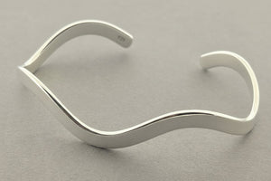 Silver bracelet on a gray background