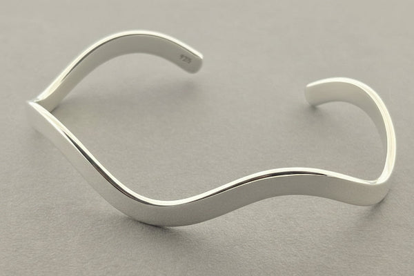 Silver bracelet on a gray background