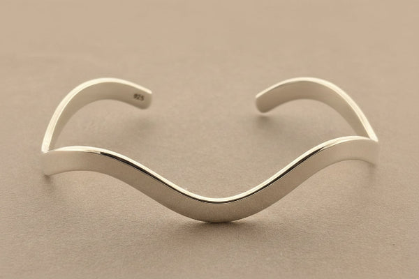 Silver bracelet on a gray background