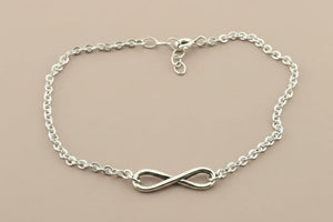 Silver infinity bracelet on a gray background