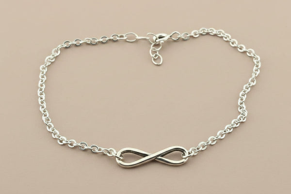 Silver infinity bracelet on a gray background