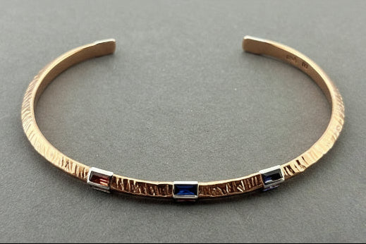 Copper & silver bracelet on a gray background