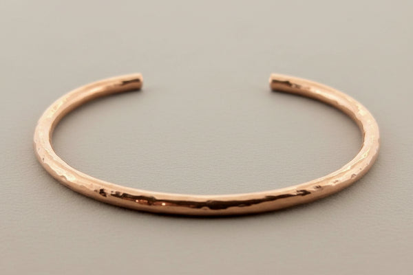Rose gold bracelet on a dark gray background
