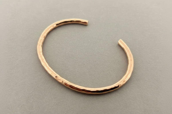 Rose gold bracelet on a gray background