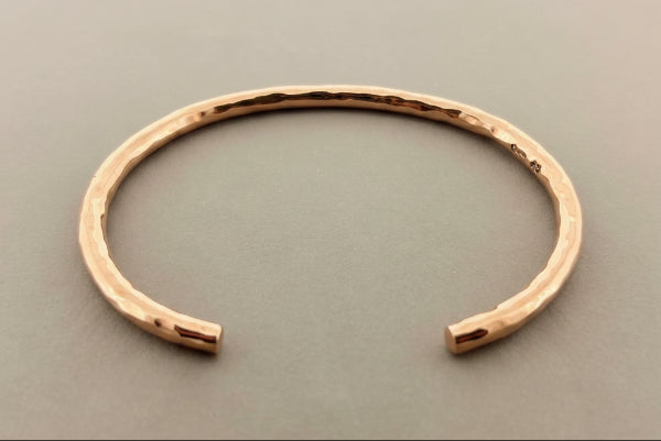 Rose gold bracelet on a gray background