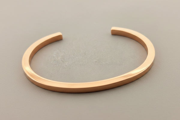 copper bracelet on a gray background