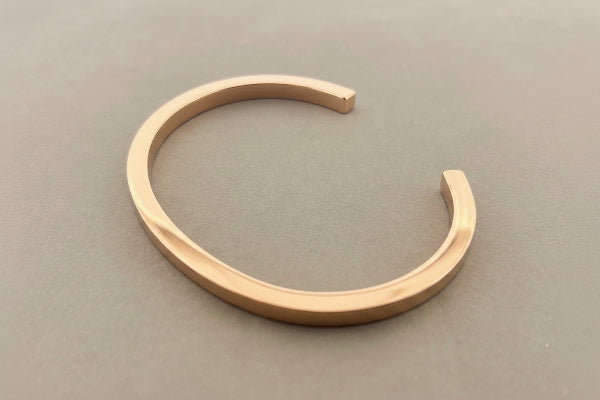 Rose gold bracelet on a gray background