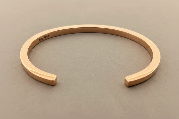 Rose gold bracelet on a gray background