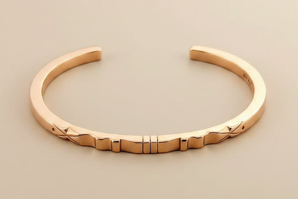 Rose gold bracelet on a gray background