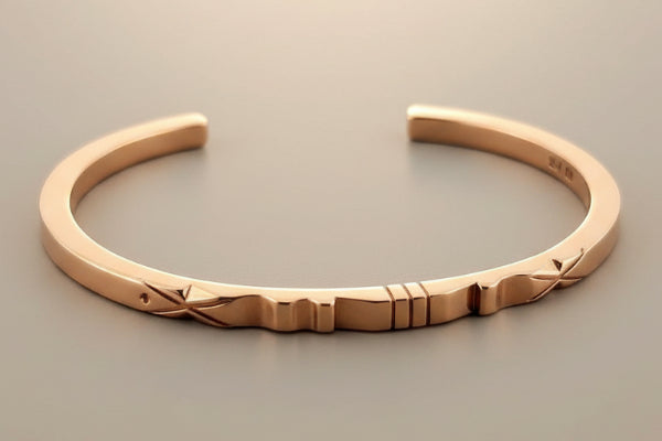 Rose gold bracelet on a gray background