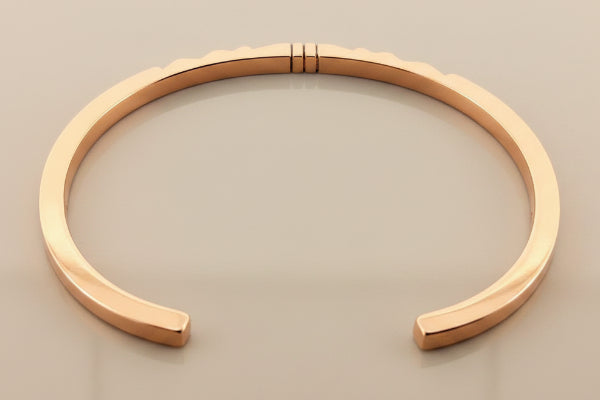 Rose gold bracelet on a dark gray background