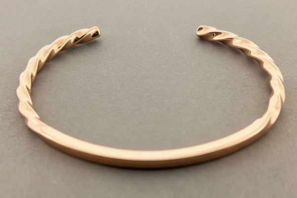 Rose gold bracelet on a dark gray background