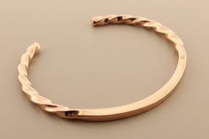 Rose gold bracelet on a dark gray background