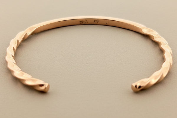 Rose gold bracelet on a dark gray background