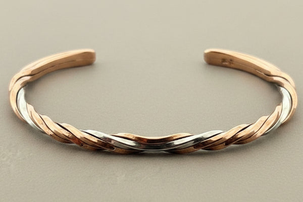 Two-tone gold and silver bracelet on a gray background