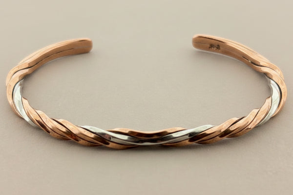 Copper and silver bangle on a gray background