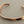 Load image into Gallery viewer, A hammered open cuff bracelet in a warm coppery metallic finish, photographed on a dark gray textured background.
