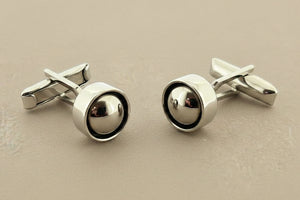 Pair of silver cufflinks on a gray background