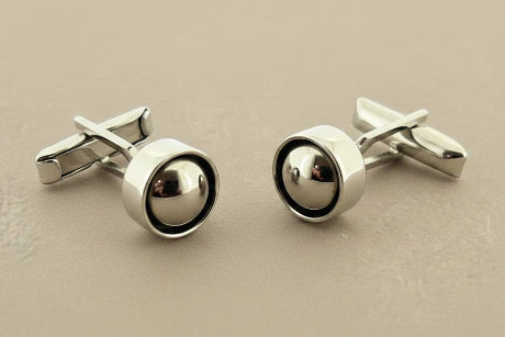 Pair of silver cufflinks on a gray background