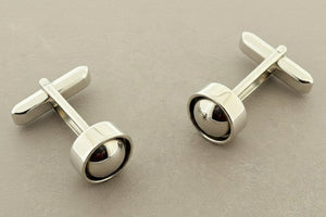 Pair of silver cufflinks on a gray background