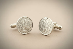 Pair of silver coin cufflinks on a gray background