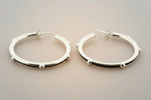 Pair of silver hoop earrings on a gray background