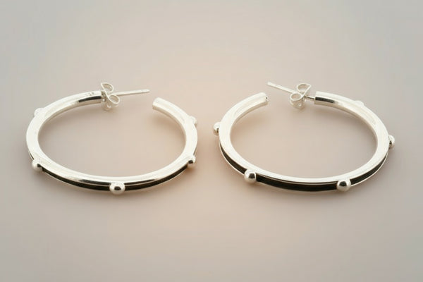 Pair of silver hoop earrings on a gray background