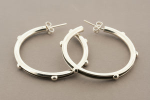 Silver hoop earrings on a gray background
