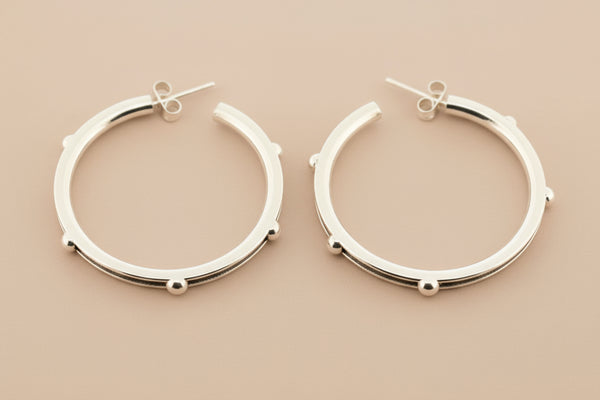 Pair of silver hoop earrings on a gray background