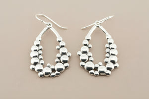 Pair of silver hoop earrings on a gray background