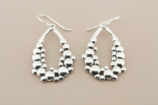 Pair of silver hoop earrings on a gray background