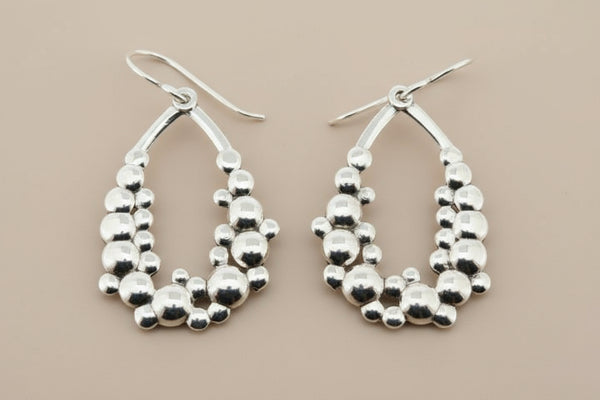 Pair of silver hoop earrings on a dark background