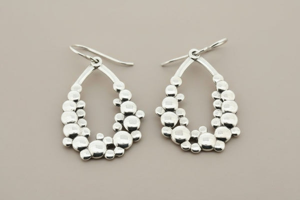 Silver hoop earrings on a dark gray background
