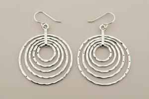 Pair of silver hoop earrings on a dark background