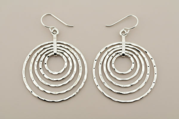 Pair of silver hoop earrings on a dark background