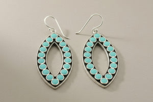 Pair of earrings with turquoise stones on a gray background