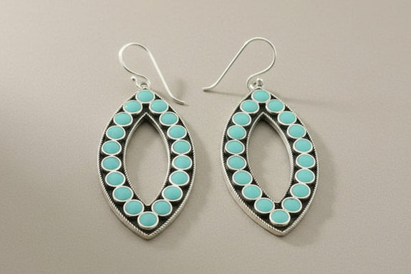 Pair of earrings with turquoise stones on a gray background