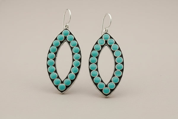 Pair of earrings with turquoise stones on a gray background
