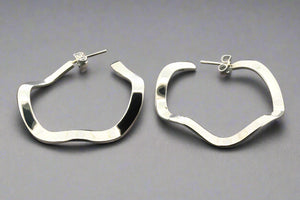 Pair of silver hoop earrings on a gray background