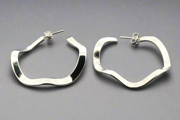 Pair of silver hoop earrings on a gray background