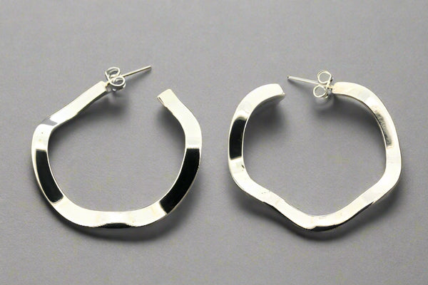 Pair of silver hoop earrings on a gray background